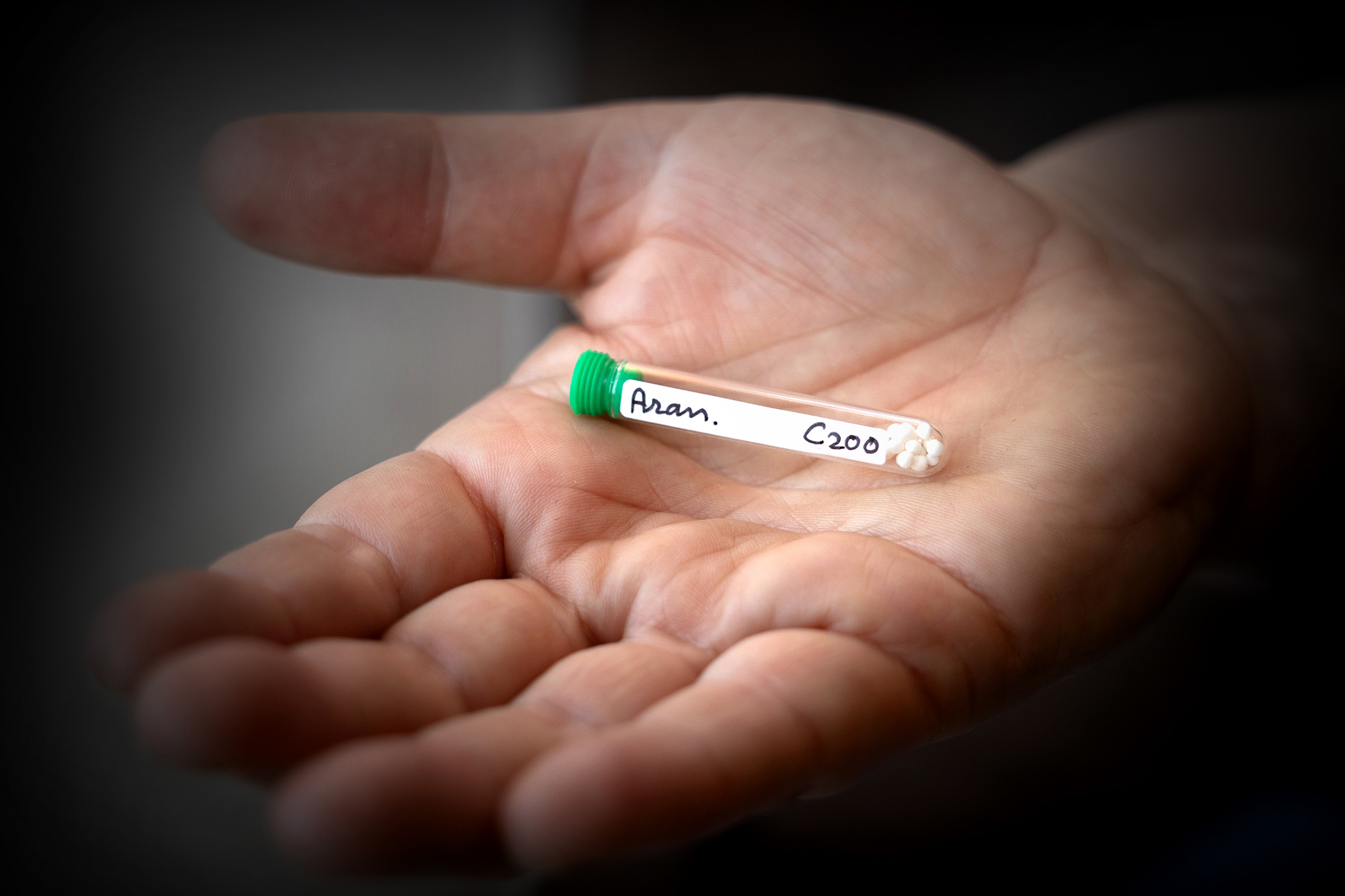 Hand met buisje homeopatische korrels